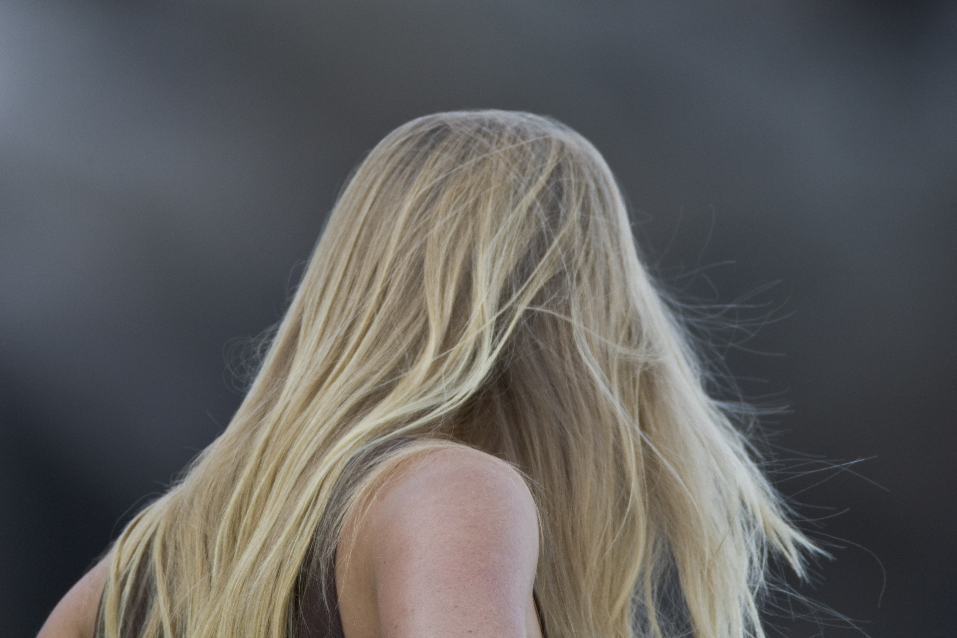 Blond long-haired young lady woman watching the surfers at Morro